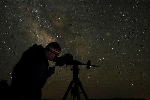 A stargazer silhouetted against the night sky.